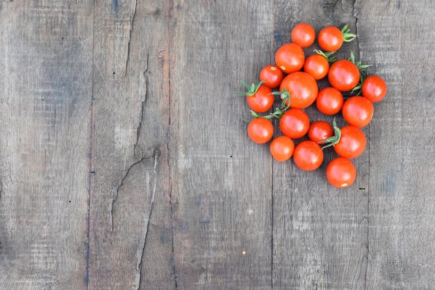 Top view of red cherry tomatoes isolated on a wooden background