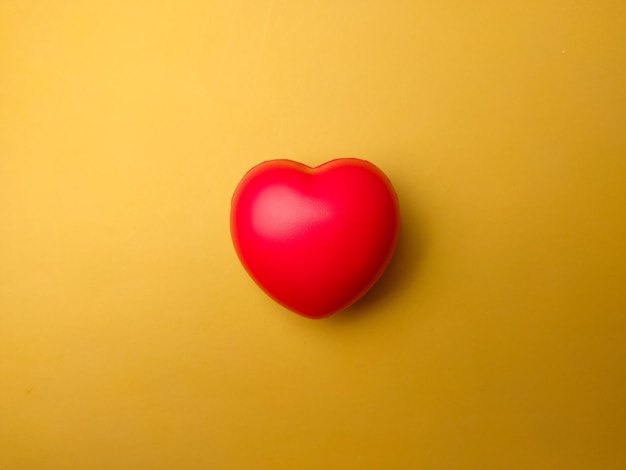 Top view red heart shape on yellow background Can use for heart check up or love concept