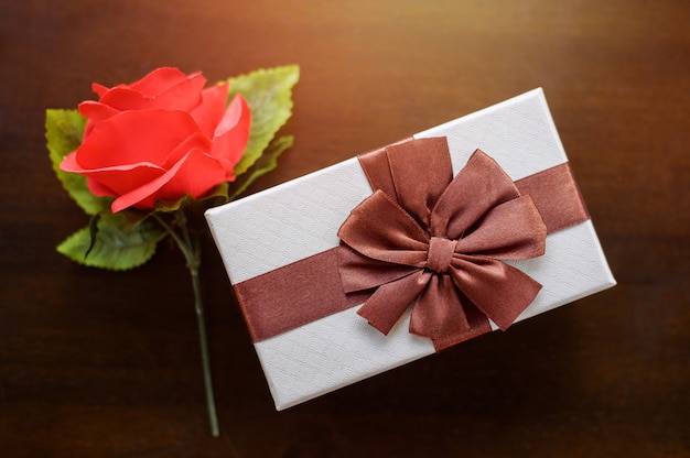 Top view of red rose and white gift