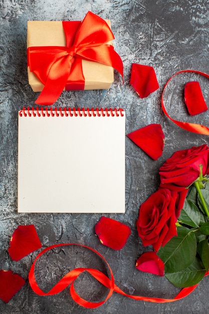 Vista dall'alto rose rosse con regali per san valentino su sfondo grigio chiaro coppia passione amore vacanza sentimento cuore