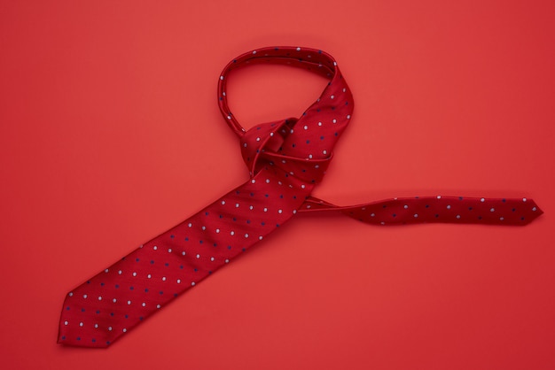 Top view on red silk tie on red background