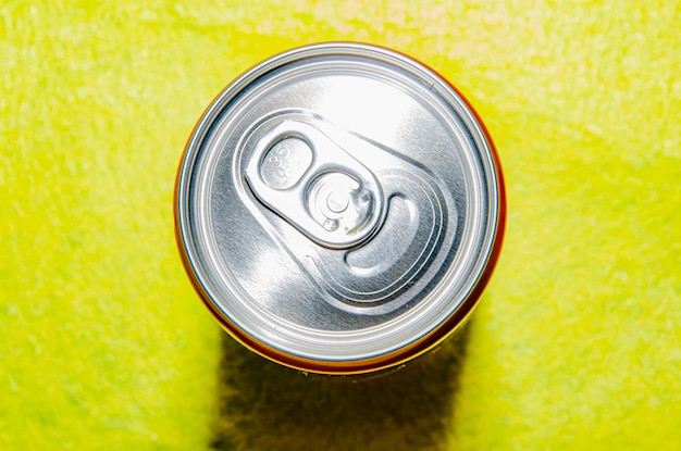 Photo top view of red soda can on yellow background.