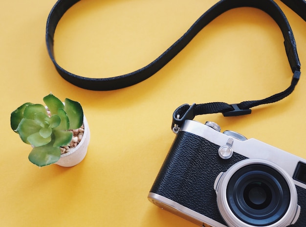 Photo top view of retro camera on yellow background.