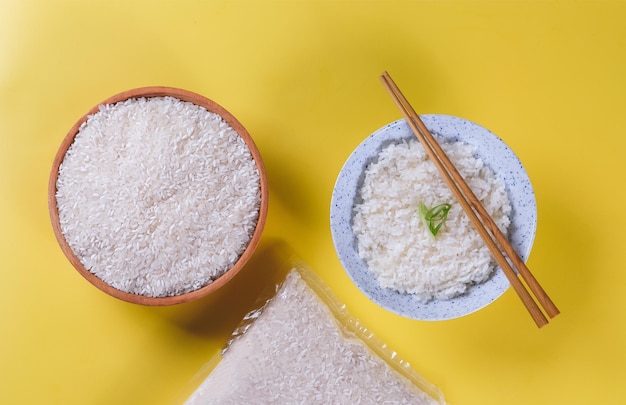 Top view of rice and chopsticks on yellow background