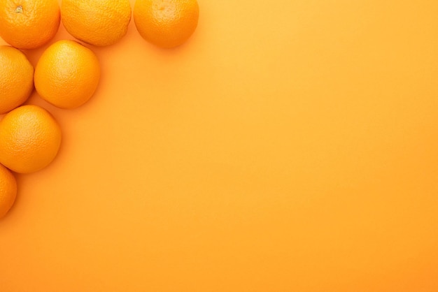 Top view of ripe juicy whole oranges on colorful background with copy space