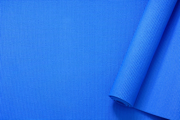 top view roll of blue color yoga mat texture background, sport and exercise concept