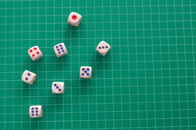 Top view rolling dice on green cutting mat background.