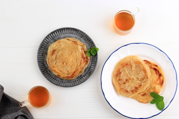 Photo top view roti canai, traditional flat bread food popular in indonesia during hari raya (ied fitr) celebration, usually served with chicken curry or beef curry. this dish came from india