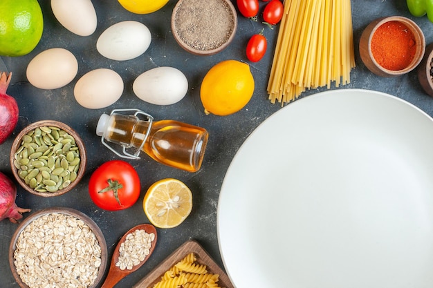 Top view round empty plate with raw pasta flour vegetables seasonings and eggs on dark background food egg milk dough dinner meal fruit