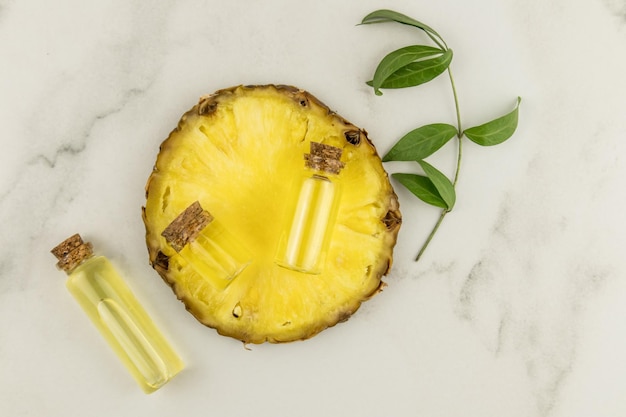 Top view of a round juicy pineapple slice with glass bottles with a stopper with a cosmetic for gentle skin care