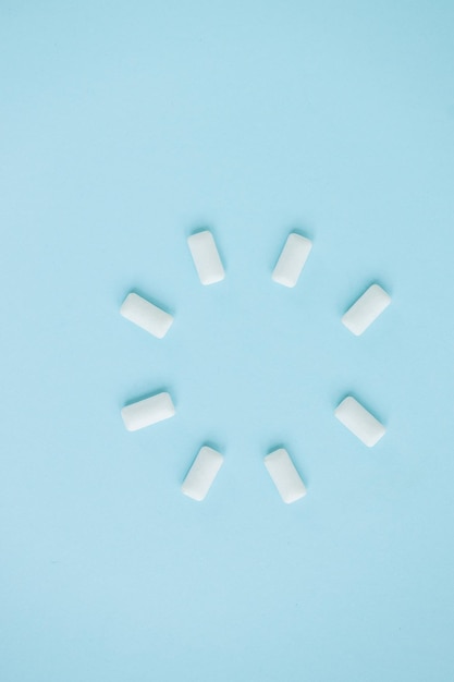 Top view of round shape from white chewing gums on blue background