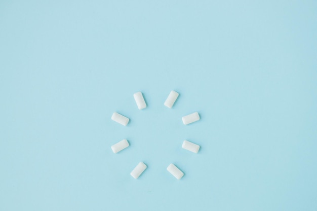 Top view of round shape from white chewing gums on blue background