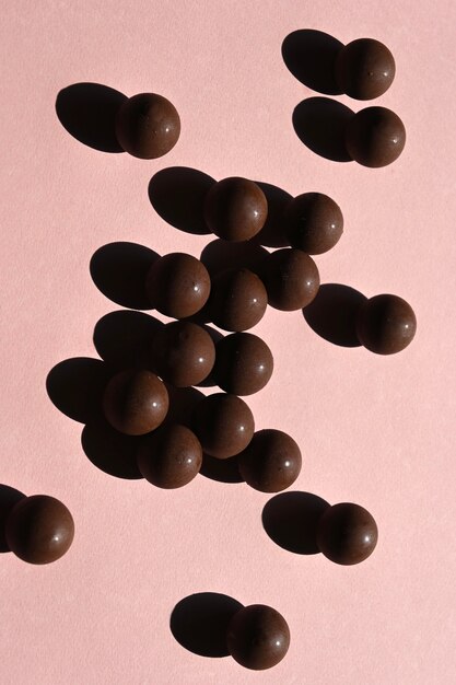 Top view of round shiny chocolates with shadows