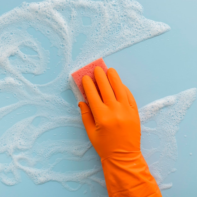 Photo top view rubber glove cleaning with sponge