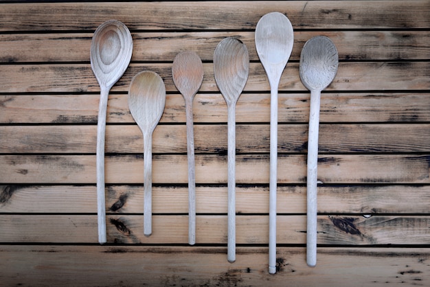 Top view on rustic wooden spatula and spoons arranged on a plank