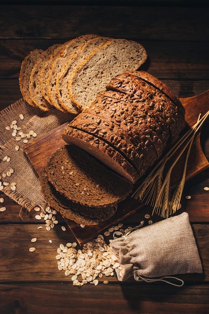 Top view of Rustic wooden table with rye bread and oats on top, rustic style