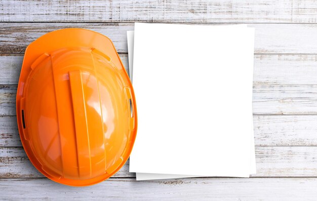 Top view safety engineer helmet on brown wooden table\
background