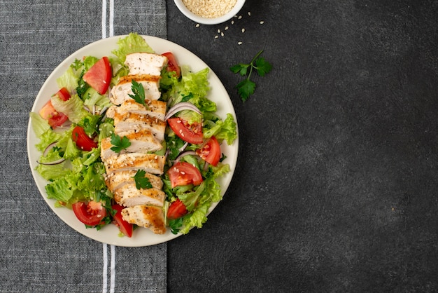 Photo top view salad with chicken on kitchen towel with copy-space