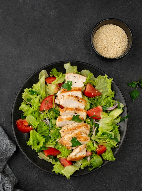 Photo top view salad with chicken and sesame seeds