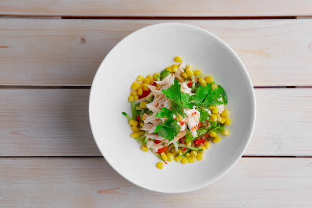 Top view of salad with corn, pepper, cucumber, chicken fillet