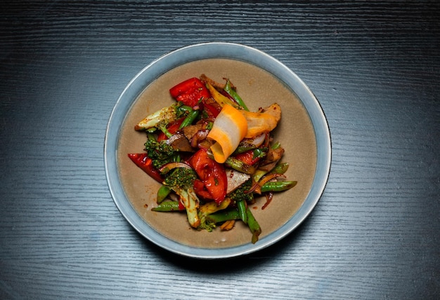 Top view of salad with meat and vegetables on a black background