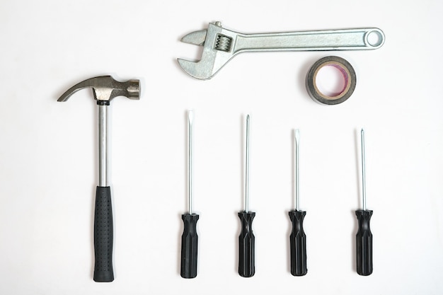 Top view of screwdrivers,hammer and wrench on white backdrop.