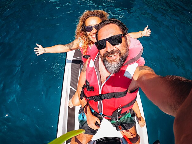 Top view selfie image of joyful young adult couple on a jet sky adventure lifestyle 