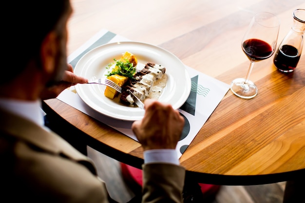 Top view of senior man eating lunch in restaurant