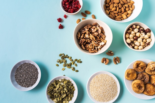 Top view the set of Superfoods in Bowls on blue Background and copy space.