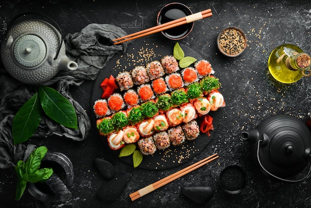 Top view set of sushi rolls on a black stone plate Traditional Japanese food On a black stone background