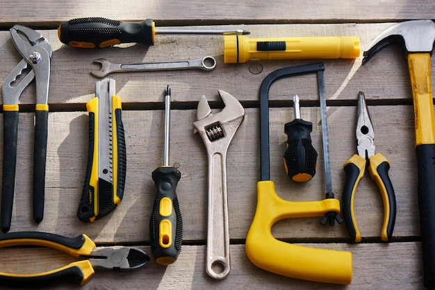 Top view of a set of tools lying on a table of wooden planks  closeup