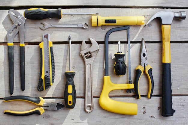 Top view of a set of tools lying on a table of wooden planks