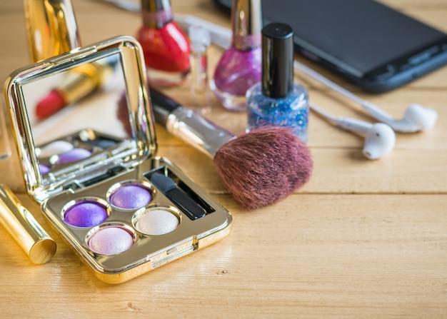 Top view of a set of women's cosmetics on a wooden vintage table.