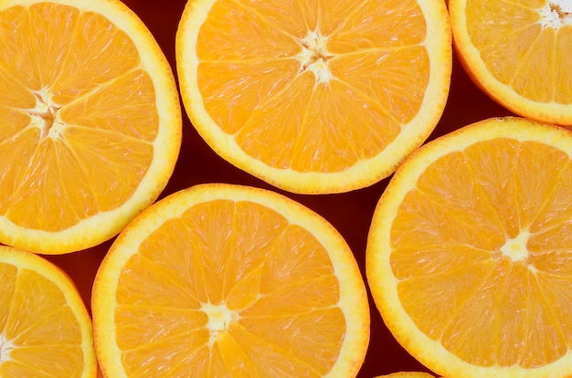 Top view of a several orange fruit slices on bright background in orange color