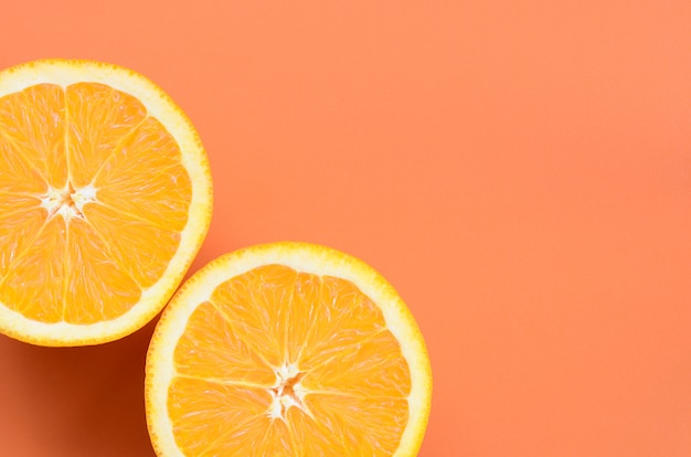 Top view of a several orange fruit slices on bright background in orange color