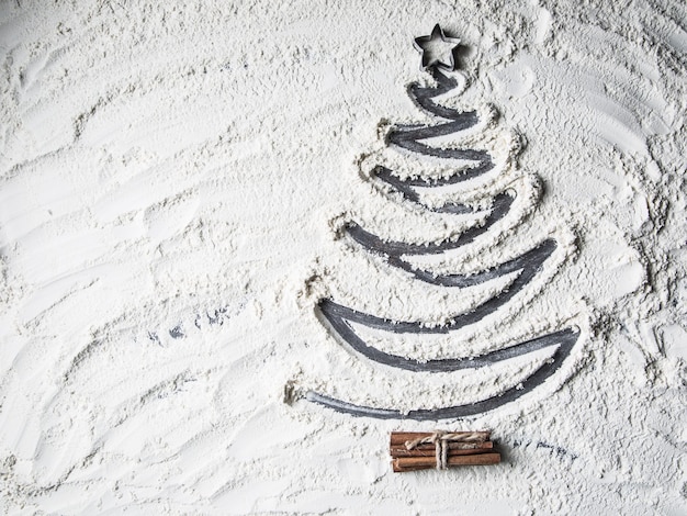 Top of view shaped christmas tree of flour star and cinnamon.