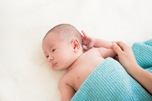 Top view of shirtless cute little newborn baby lying on the bed