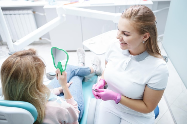 Vista dall'alto di un'affascinante giovane dentista che parla con il suo paziente dopo un controllo dentale