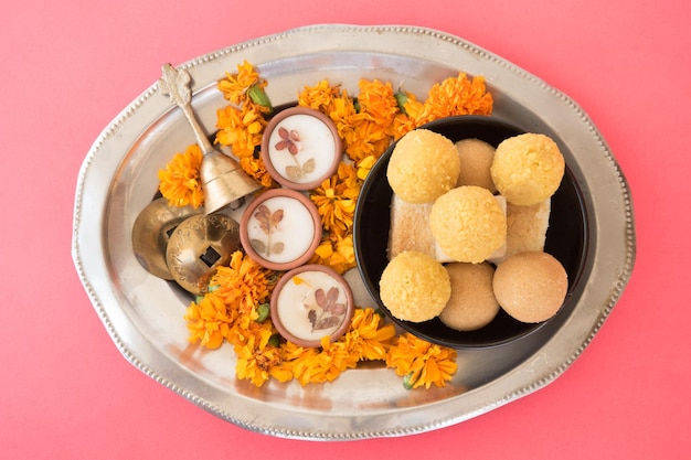 Вид сверху на индийские традиционные сладости на розовом фоне