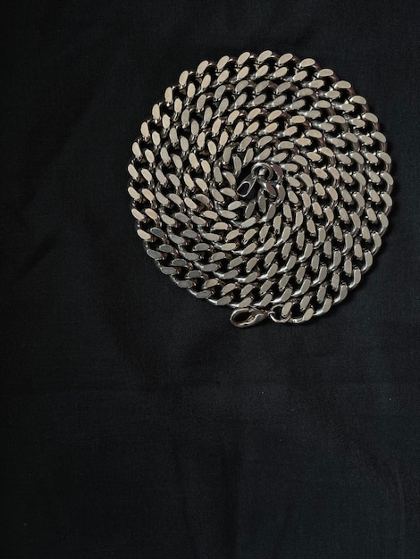 Top view shot of a metal necklace chain on black background