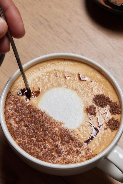 사진 바리스타가 준비하는 커피 한 잔에 항아리에서 우유를 붓는 전문 바리스타의 탑 뷰 샷 커피 한 잔을 들고 있는 손에 집중하세요