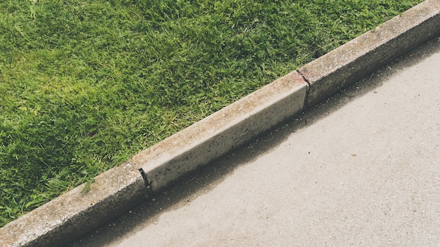 Top view shot of the pavement curb next to a grass