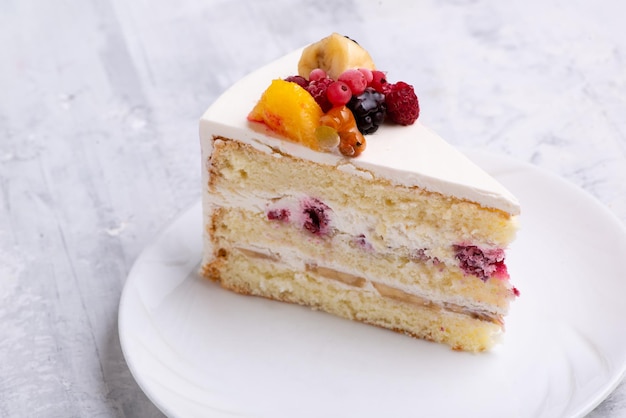 Top view shot of sliced white fruit cake on a white plate