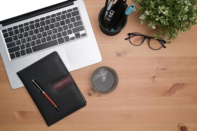 Top view simple workspace with laptop computer notebook and\
coffee cup on wooden table