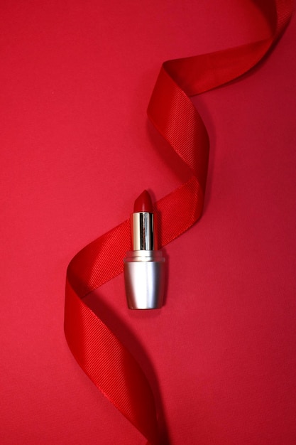 Top view of single tube of red lipstick on red