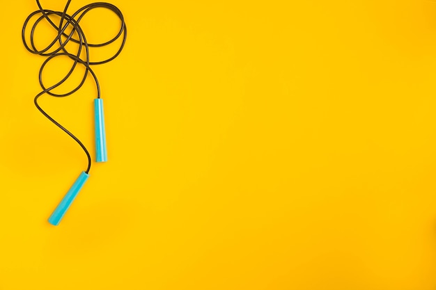 Top view of skipping rope on yellow background