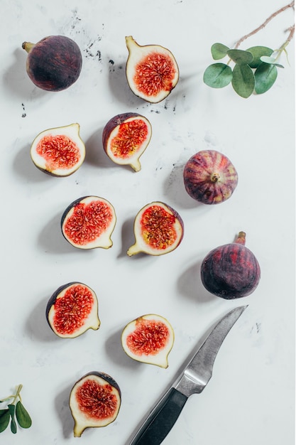 Top view of sliced ââfigs and knife on white background