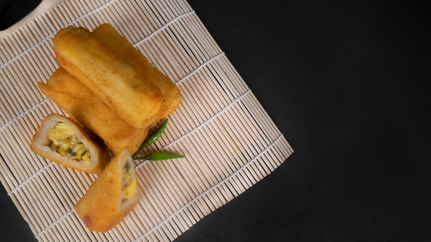 Top view sliced Indonesian Rissoles on a black background