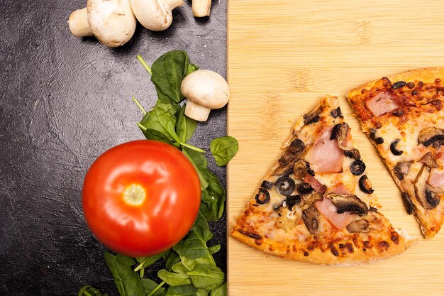 Foto vista dall'alto su fette di pizza su una tavola su un tavolo di legno scuro