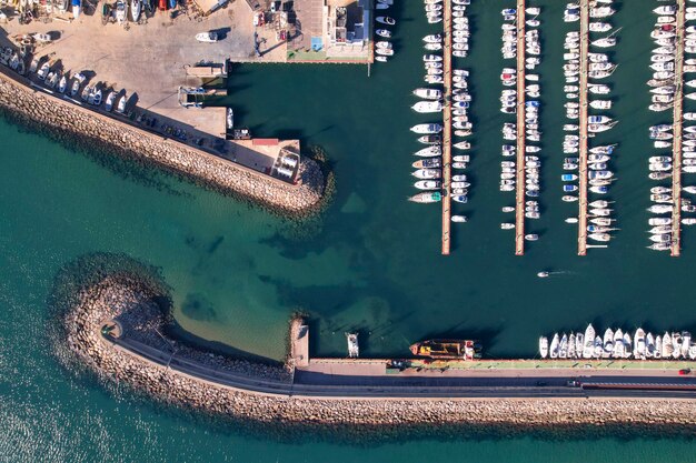 Foto vista dall'alto di un piccolo porto nautico con diverse file di piccole barche ormeggiate